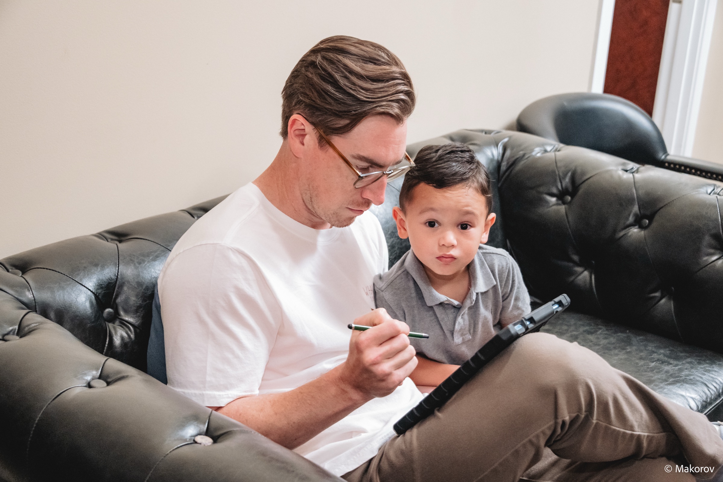 Father and young son filling out forms in the Landmark Smiles waiting room