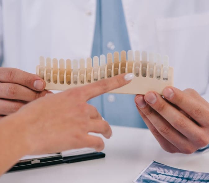 Dentist showing a veneer shade guide to a patient